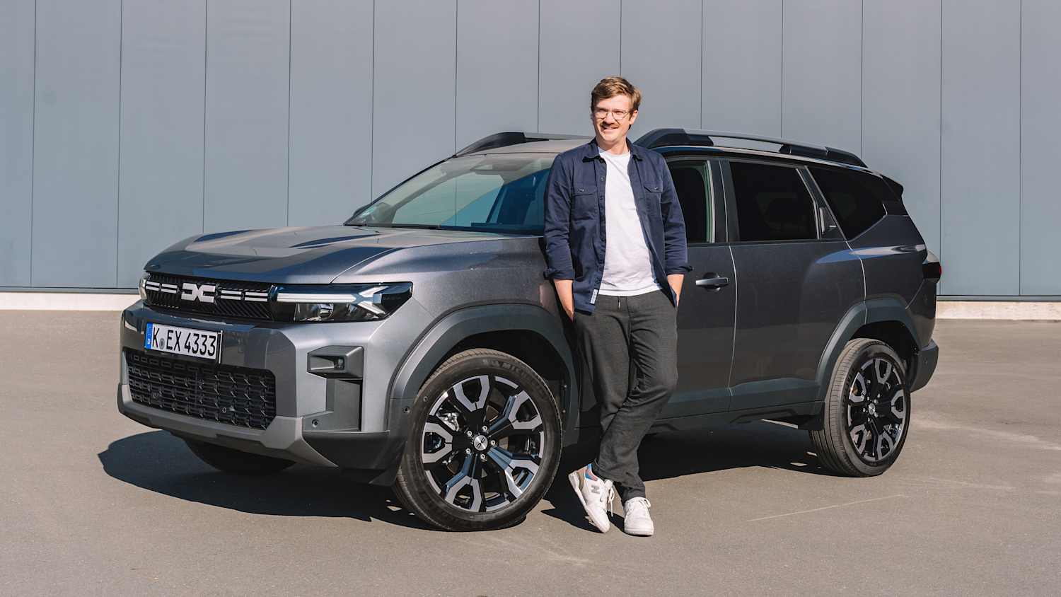 ADAC Redakteur Andreas Huber steht neben einem Dacia Bigster