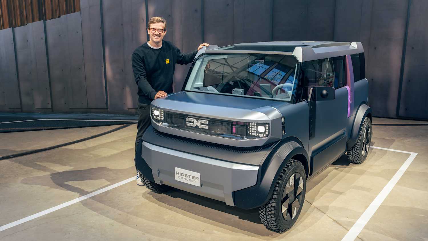 ADAC Redakteur Andreas Huber steht neben einem Dacia Hipster Concept