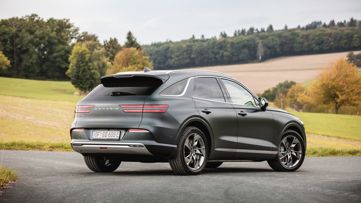 Standbild des Genesis Electrified GV70 schräg von hinten.