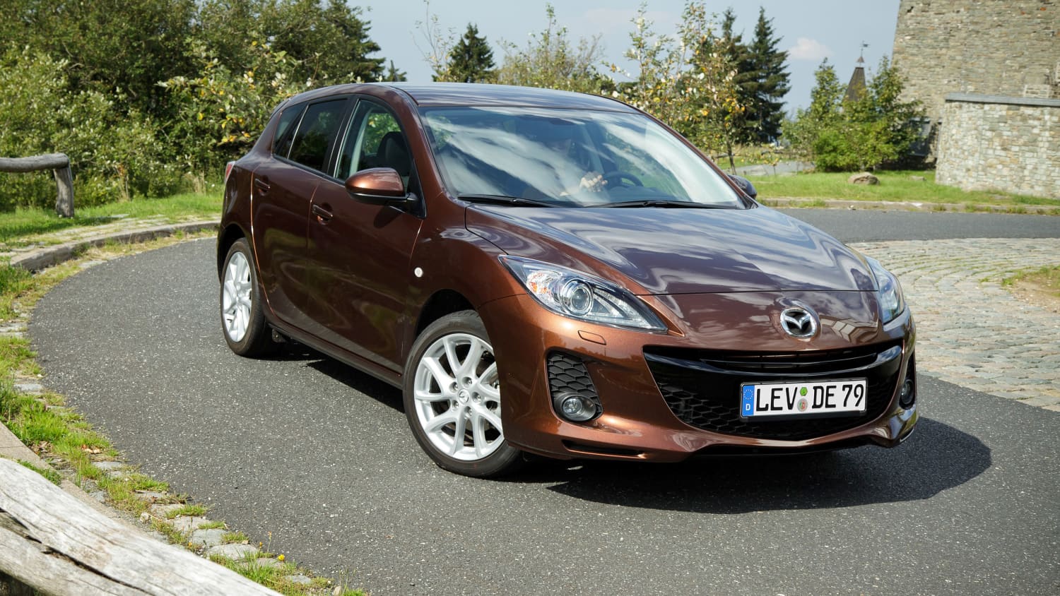 Front und Seitenansicht eines fahrenden Mazda 3