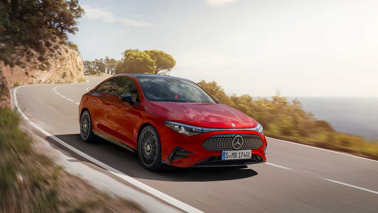 Der frontal fahrende Mercedes CLA auf einer Landstraße am Meer