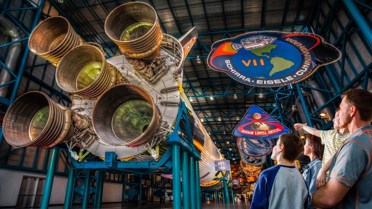 Eine Familie bewundert eine Saturn-V Trägerrakete im Apollo/Saturn V Center