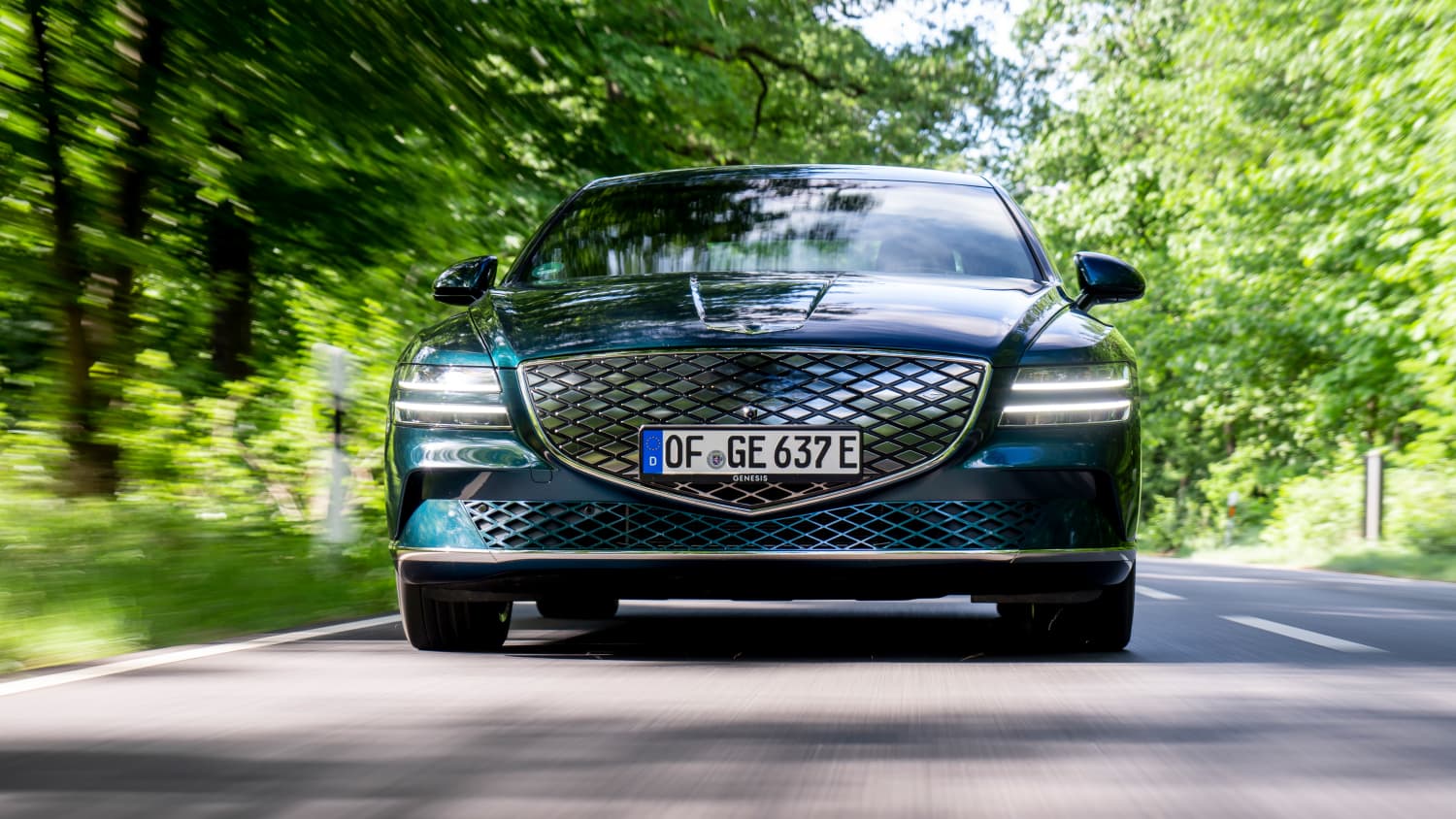 Frontansicht eines fahrenden Genesis electrified G80