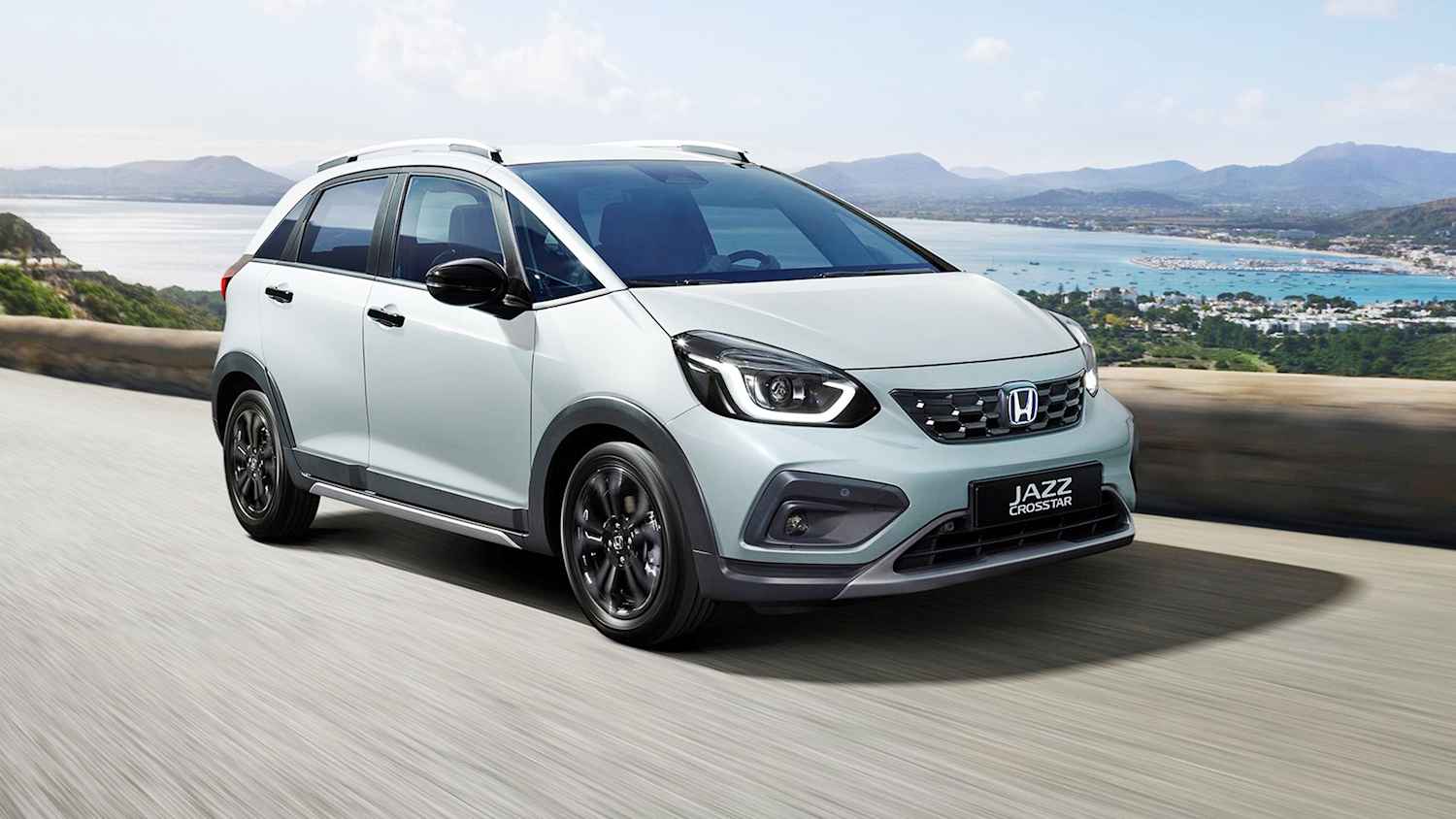 Der Honda Jazz fahrend auf einer Landstraße am Meer
