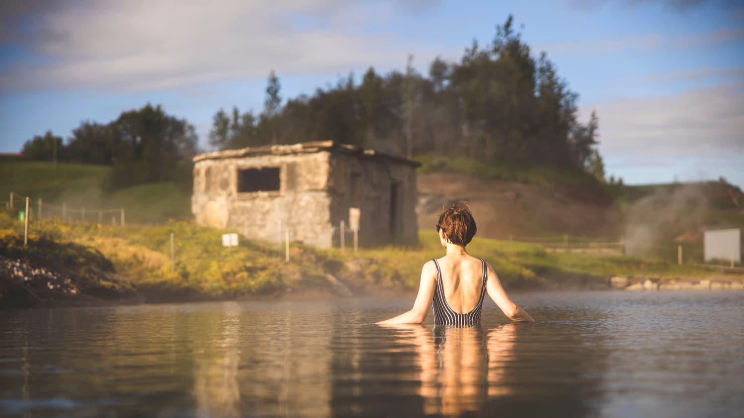 Frau schwimmt in der Secret Lagoon in Island