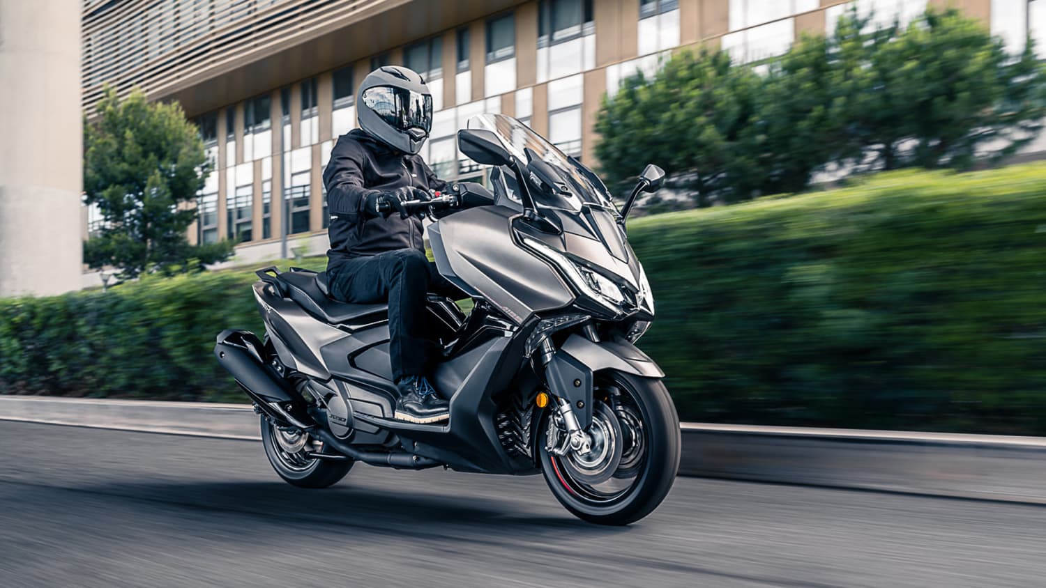 Eine Kymco AK 550i ABS Premium fahrend auf einer Straße