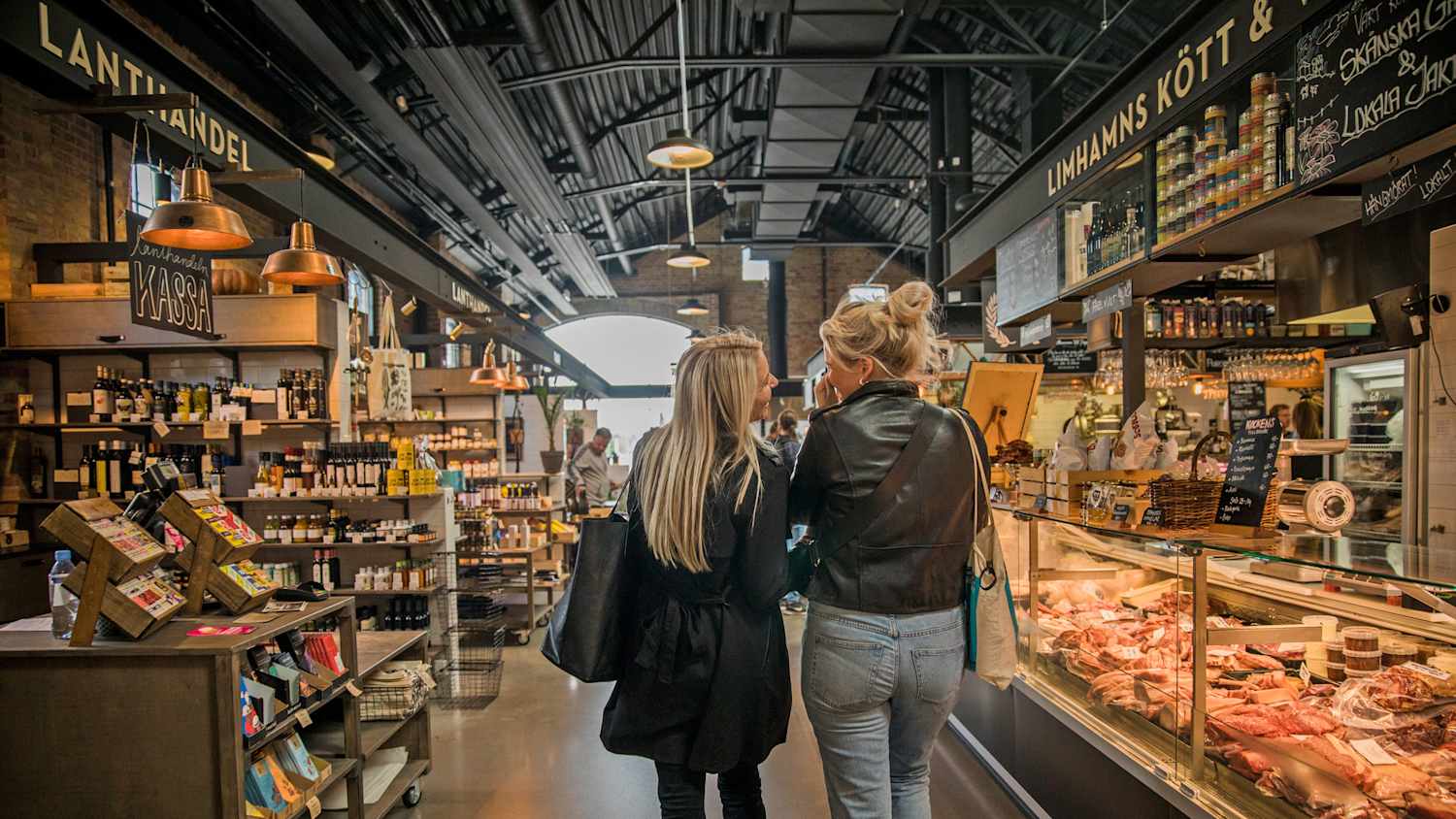 Zwei Frauen schlendern durch die Markthalle Saluhall in Malmö