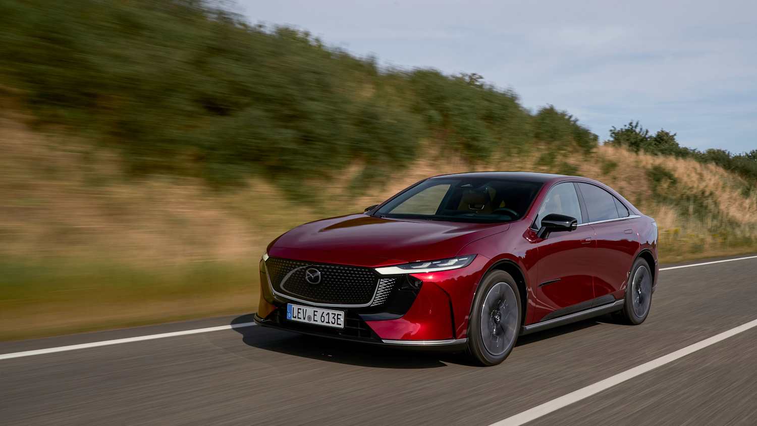 Der fahrende Mazda 6e von vorne auf einer Landstraße