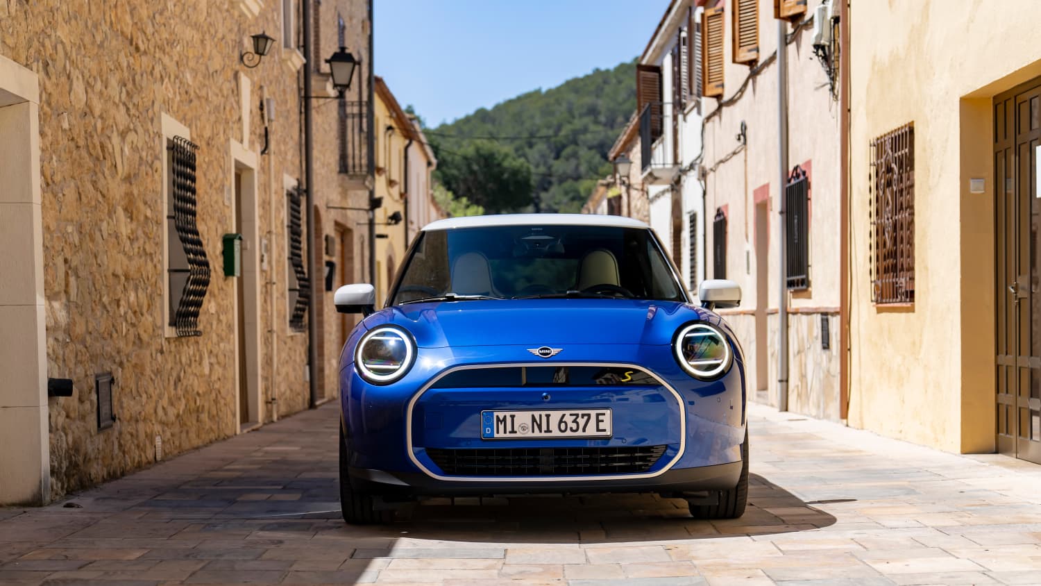 Ein Mini Cooper E  fährt durch eine schmale Gasse