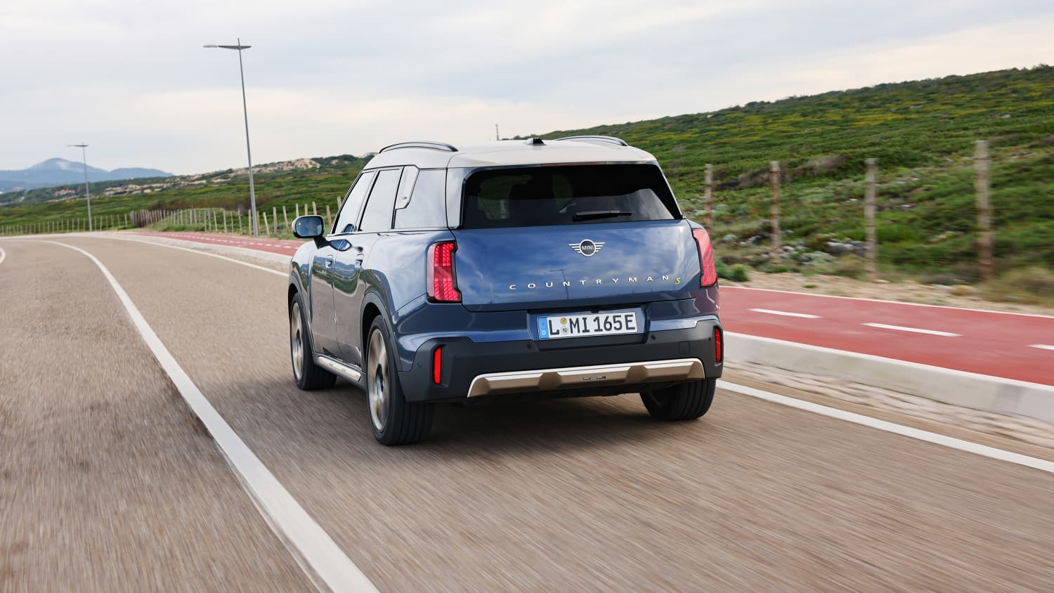 Die E-Version des Mini Countryman fahrend mit Heckansicht