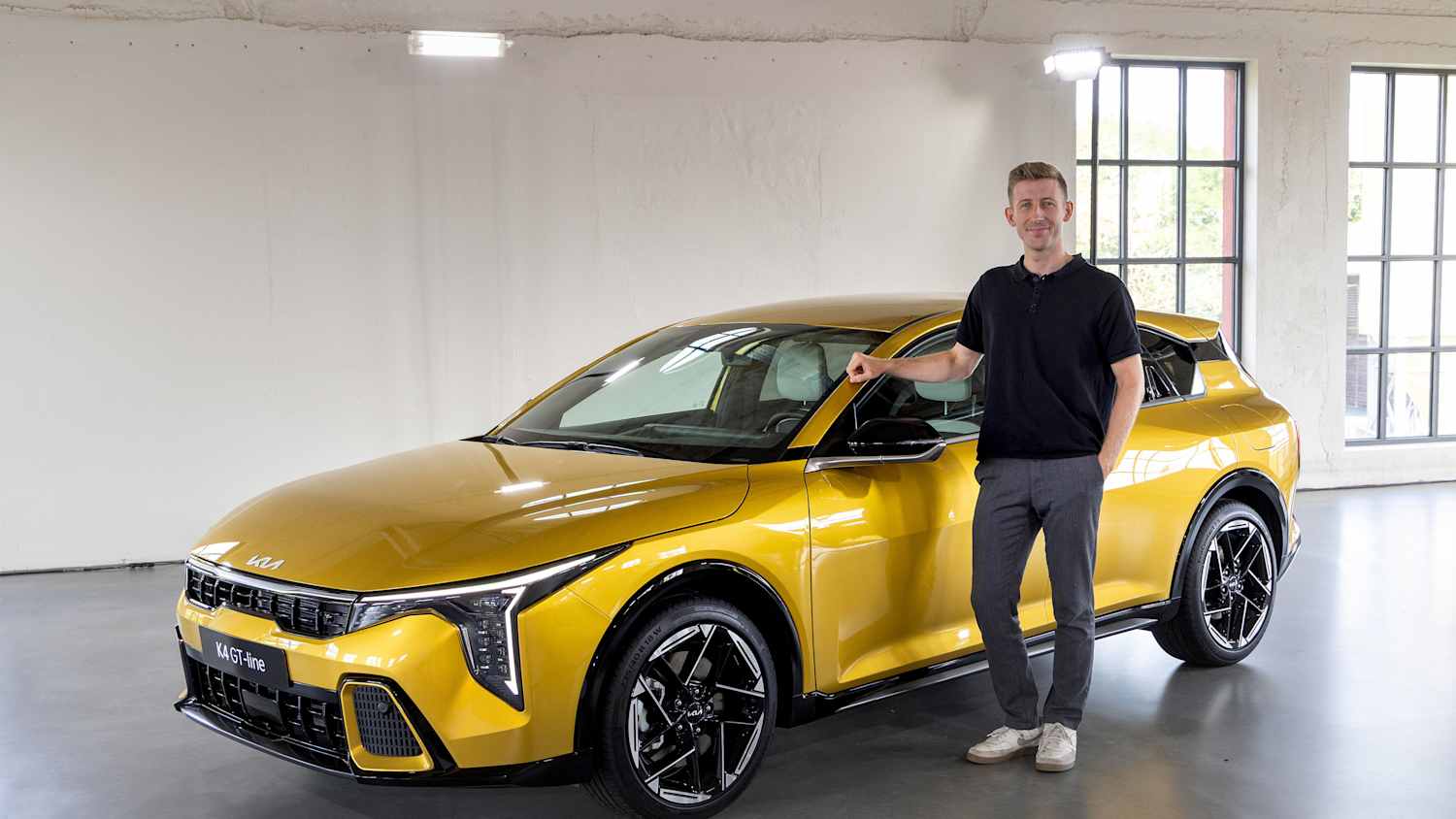 ADAC Redakteur Lorenzo Walcher stehend neben dem neuen Kia K4