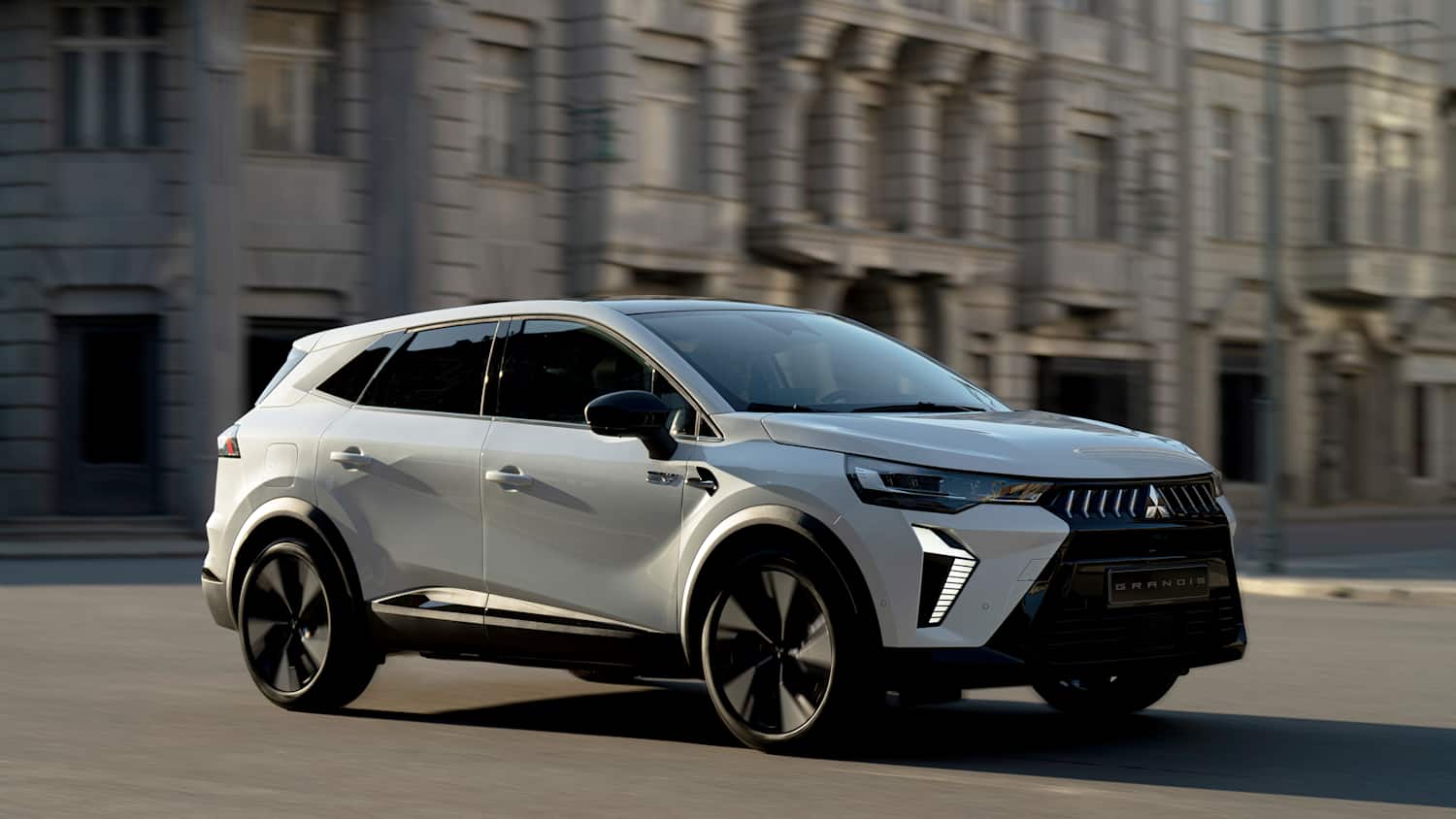Der neue Mitsubishi Grandis von der Seite fahrend in einer Stadt fotografiert