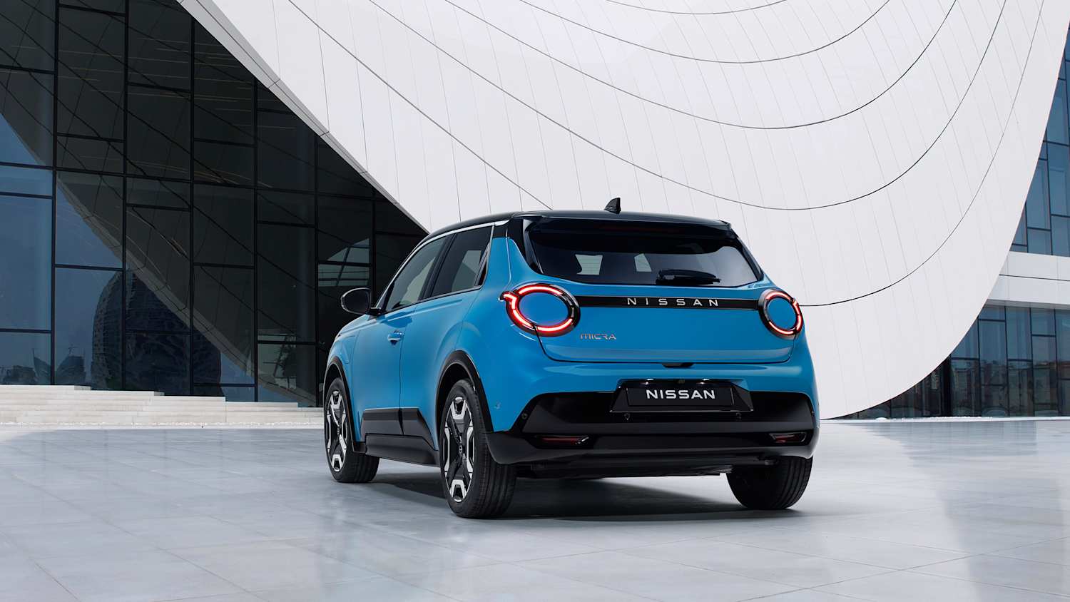 Der neue Nissan Micra in blauer Farbe seitlich stehend von hinten fotografiert