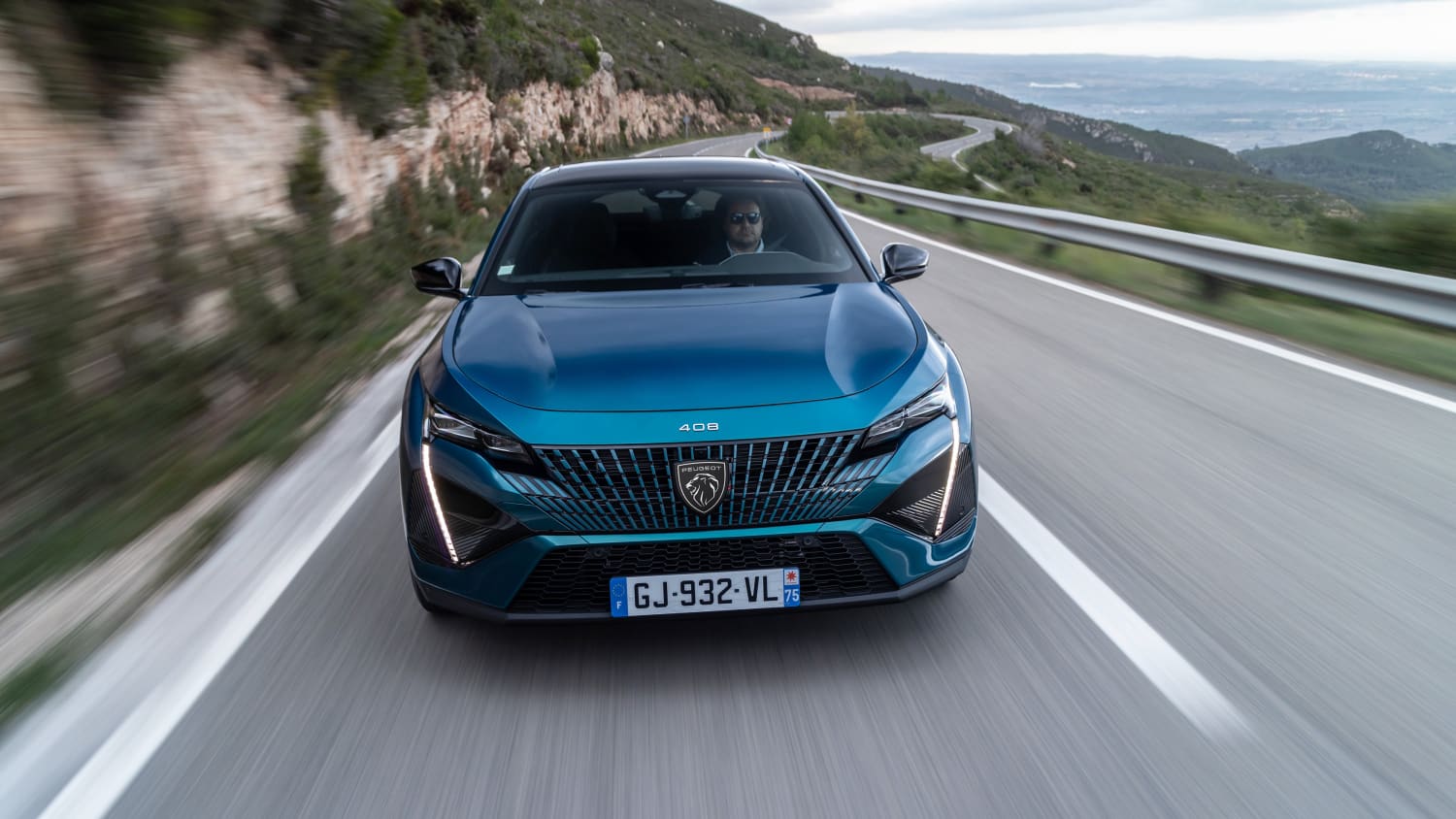 Frontansicht des neuen petrolfarbenen Peugeot 408 während der Fahrt