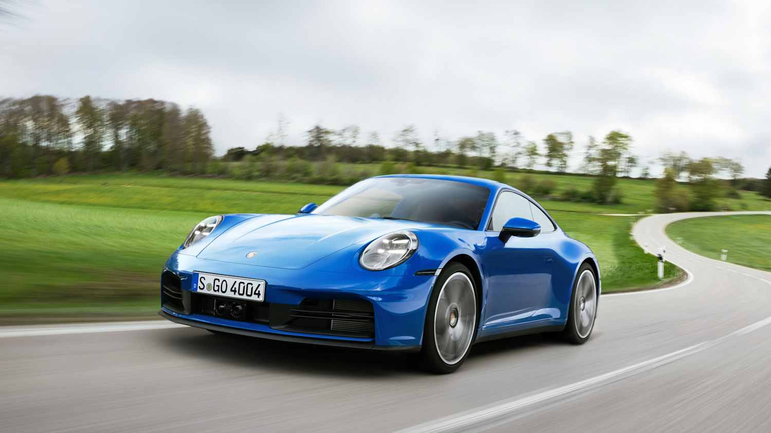Ein blauer Porsche 911 Carrera wärend der Fahrt schräg von Vorne.