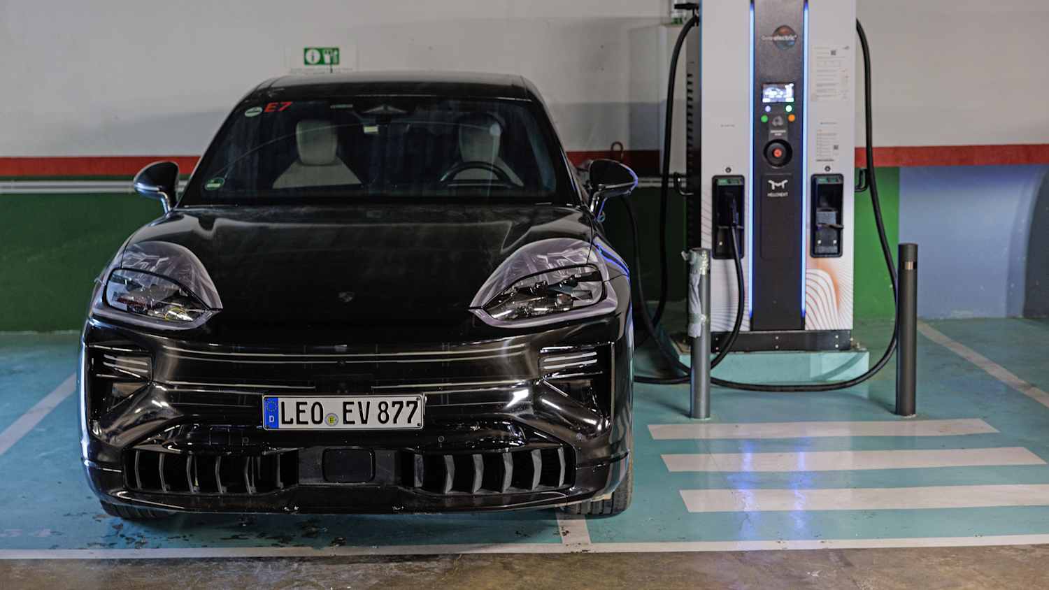 Ein Porsche Cayenne E ist an einer Ladesäule angeschlossen und wird aufgeladen