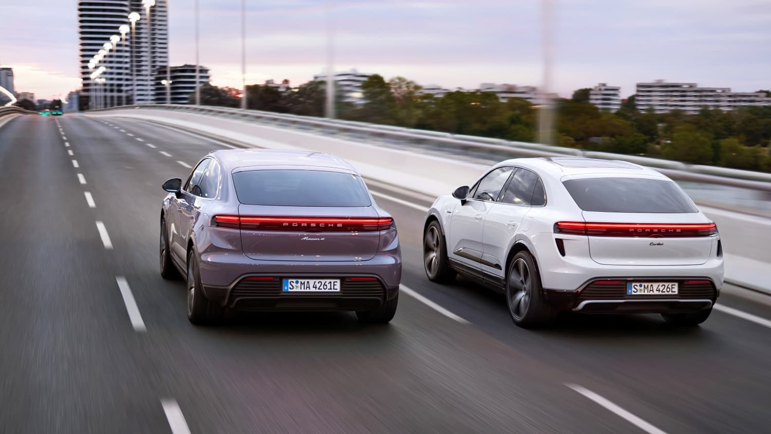 Der Porsche Macan 4 und der Macan Turbo fahrend von hinten