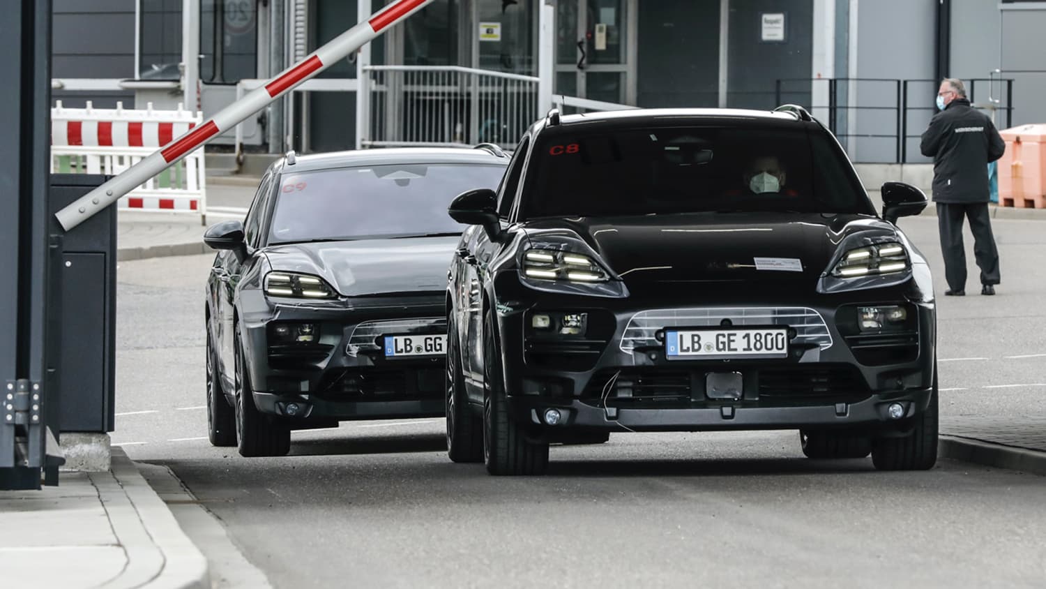 Zwei Prototypen des Porsche Macan E fahren vom Werksgelände in Weissach