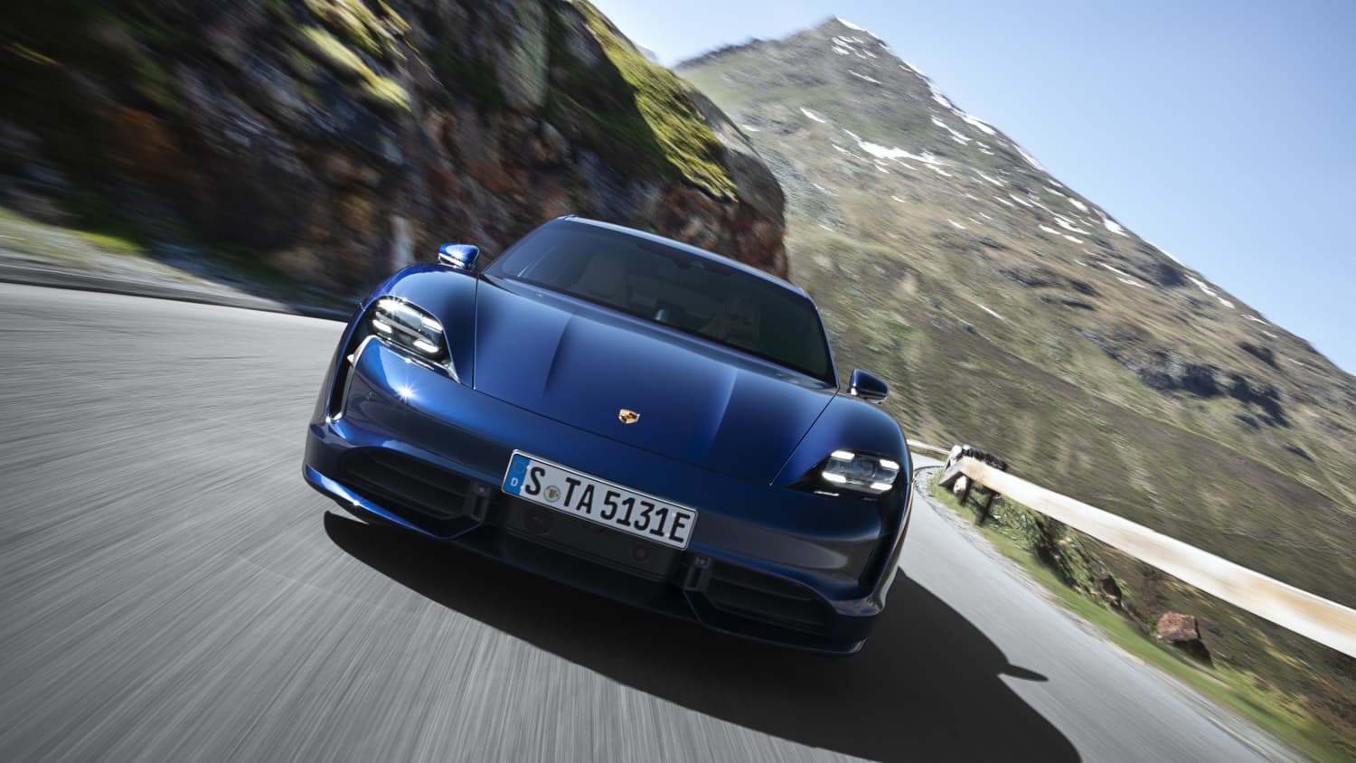 auf Landstrasse fahrender Porsche Taycan