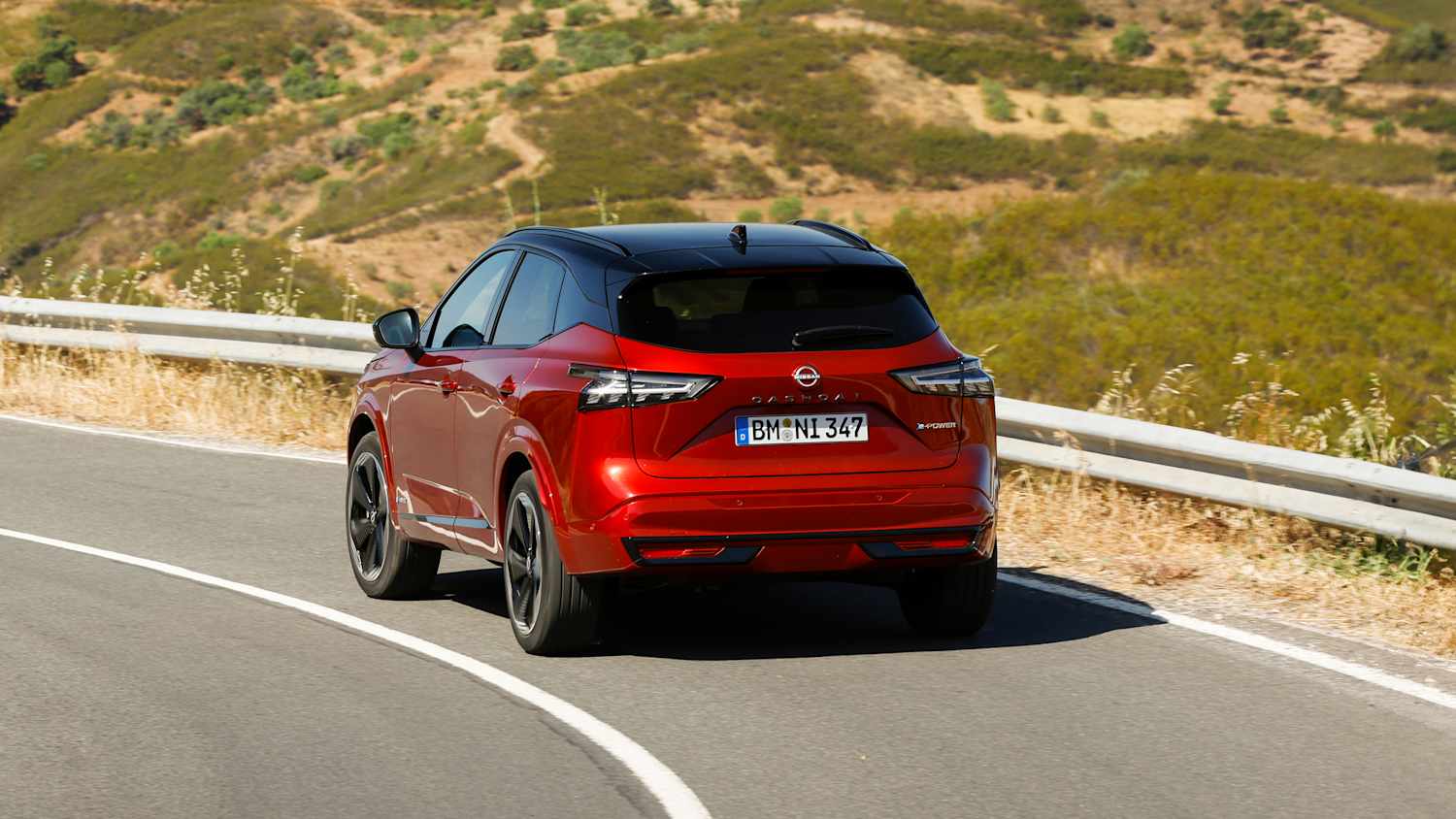 Aufnahmen des fahrenden Nissan Qashqai auf einer Landstraße bei Sonnenuntergang