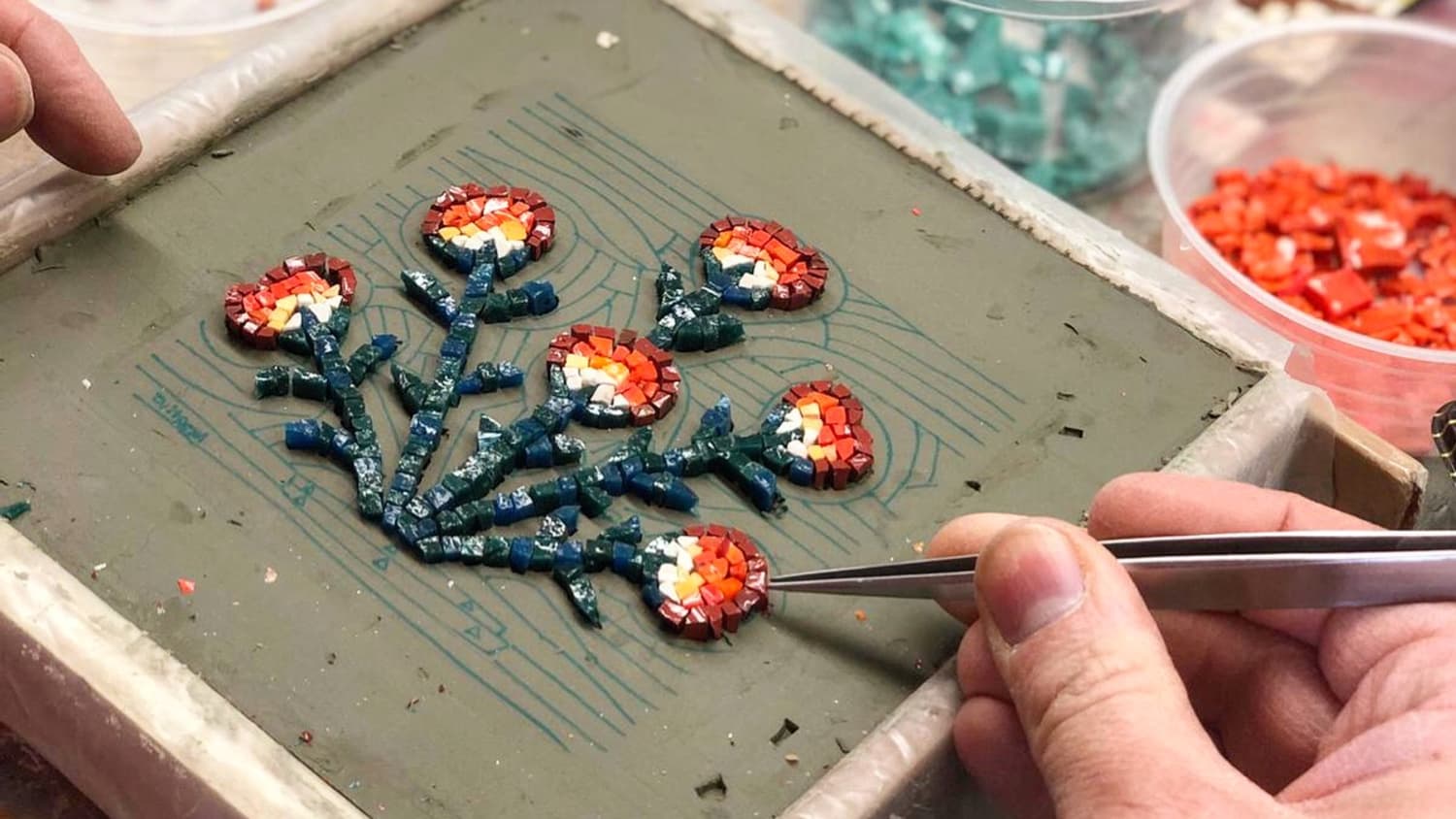 Mann bastelt an kleinem Blumen-Mosaik