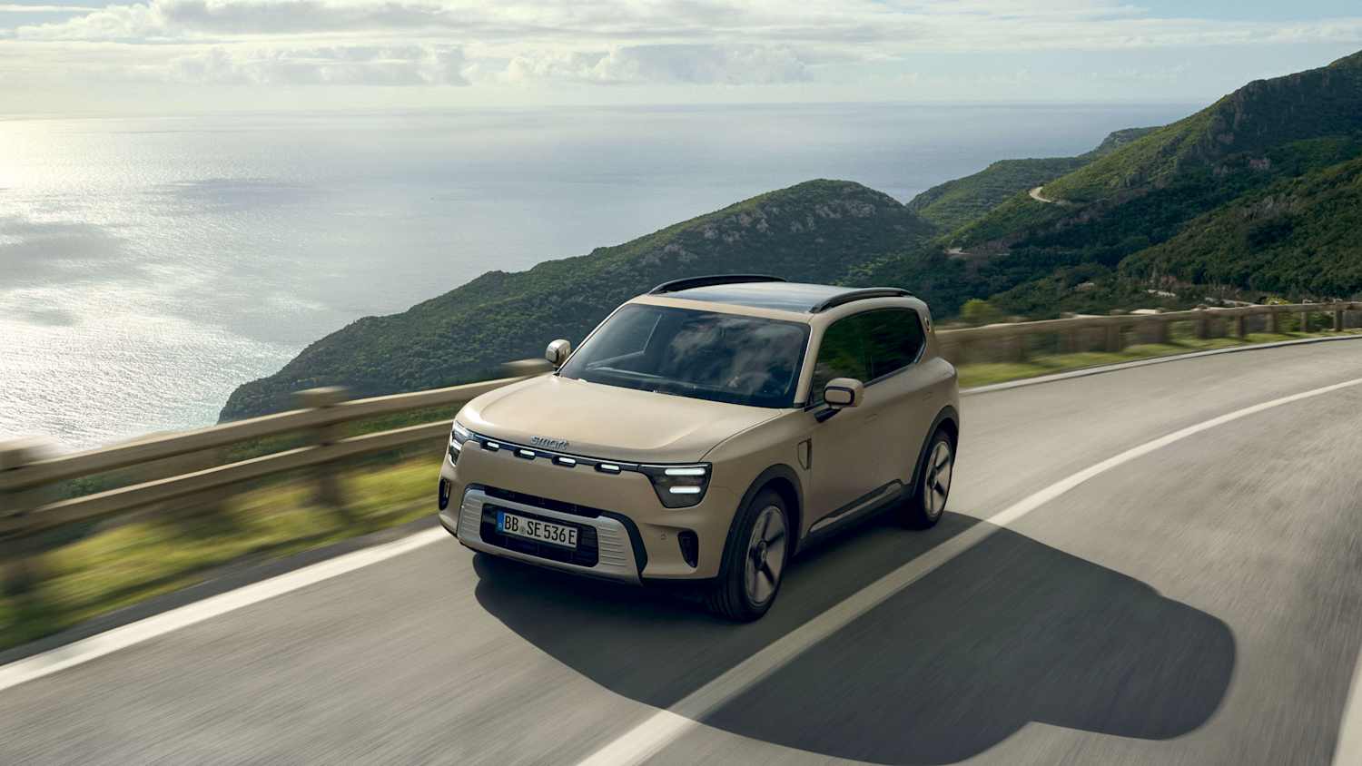 Der neue Smart #5 fahrend auf einer Straße von vorne zu sehen
