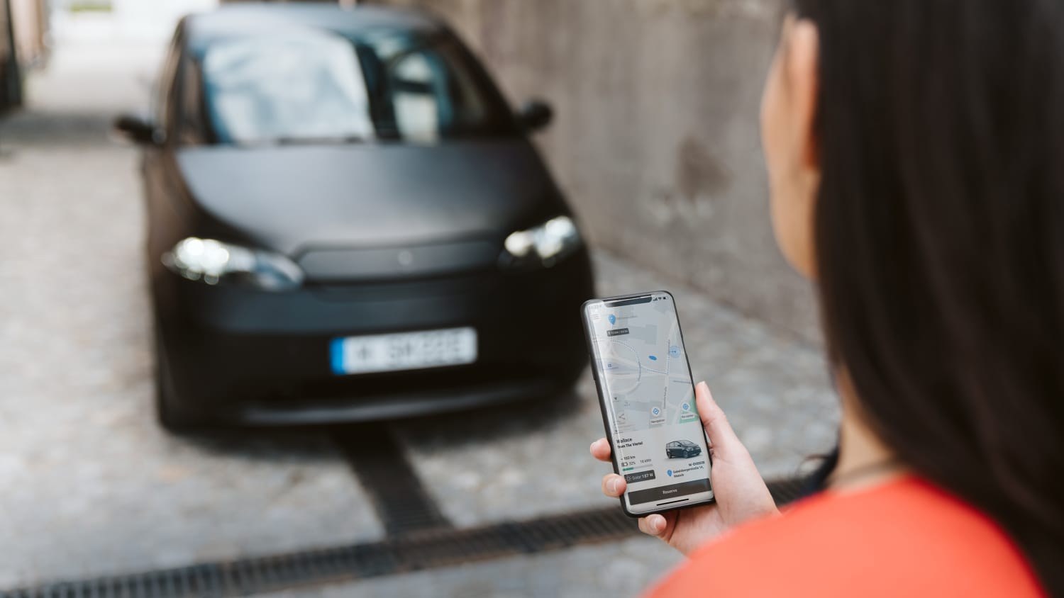 Eine Frau bedient die Sono Motors App
