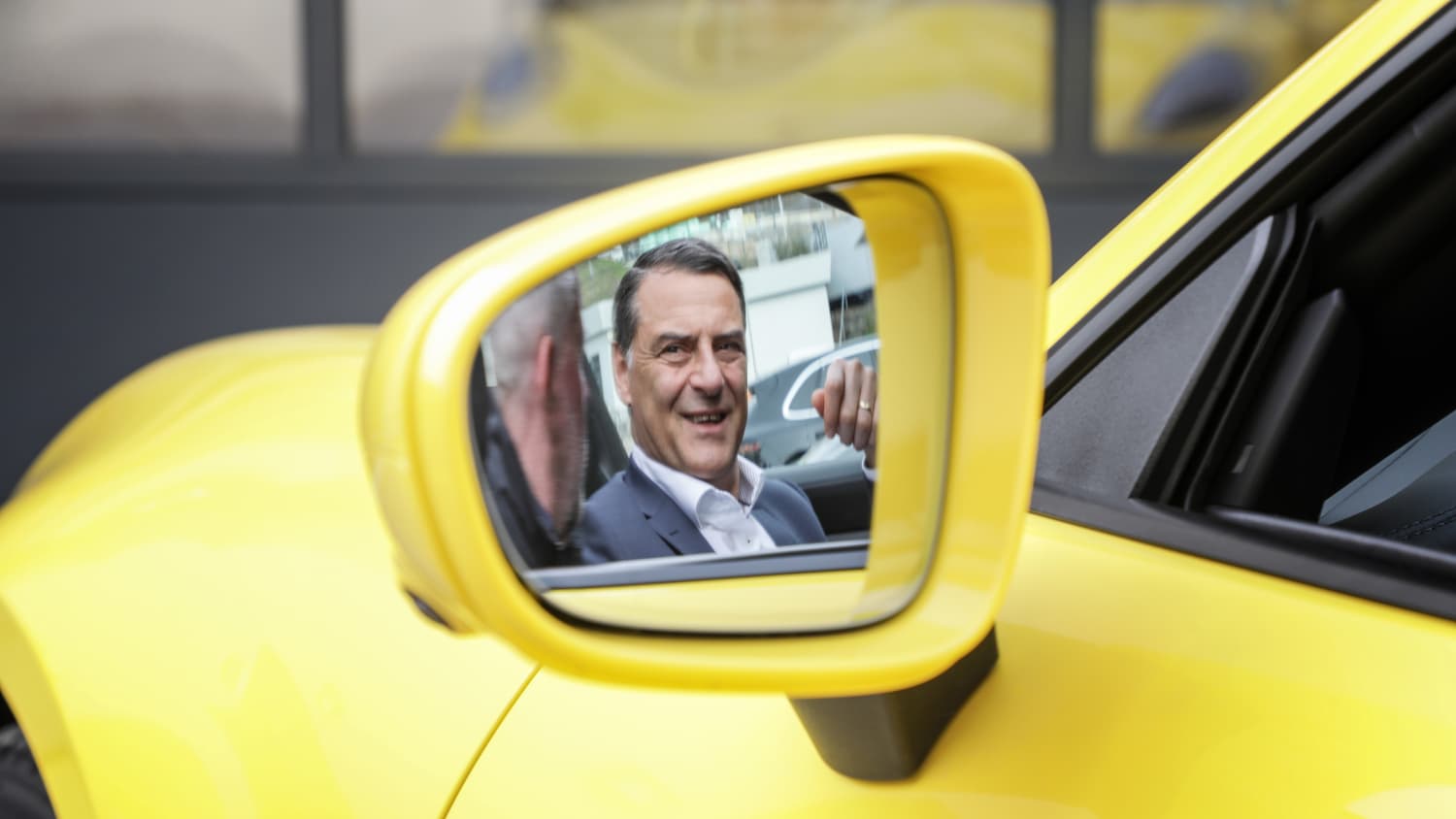 Porsche Entwicklungs- Vorstand Dr. Michael Steiner im Seitenspiegel des neuen gelben Porsche 911