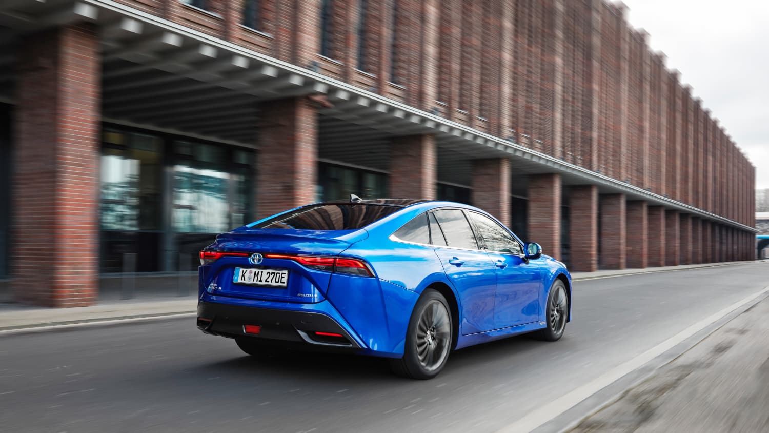 Ein blauer Toyota Mirai von hinten während der Fahrt durch die Stadt