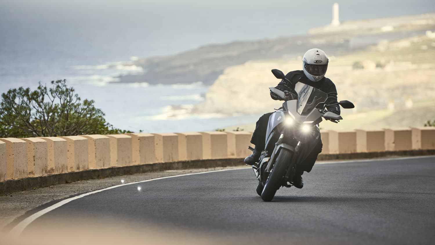 Motorradfahrer fährt eine Yamaha Tracer 700 auf einer Küstenstrasse