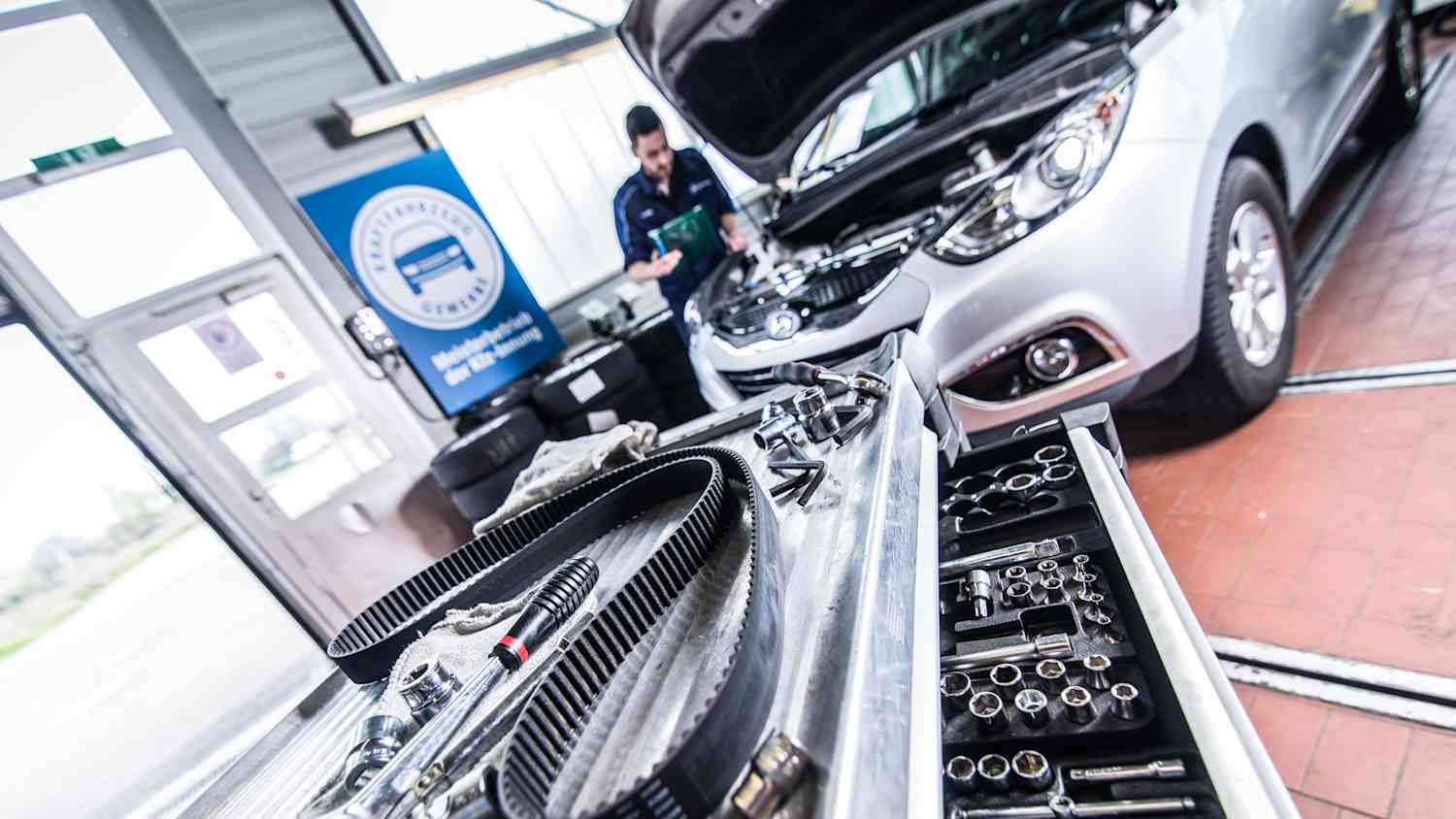 Ein neuer Zahnriemen liegt in einer Autowerkstatt auf einem Tisch, fertig zum Einbau