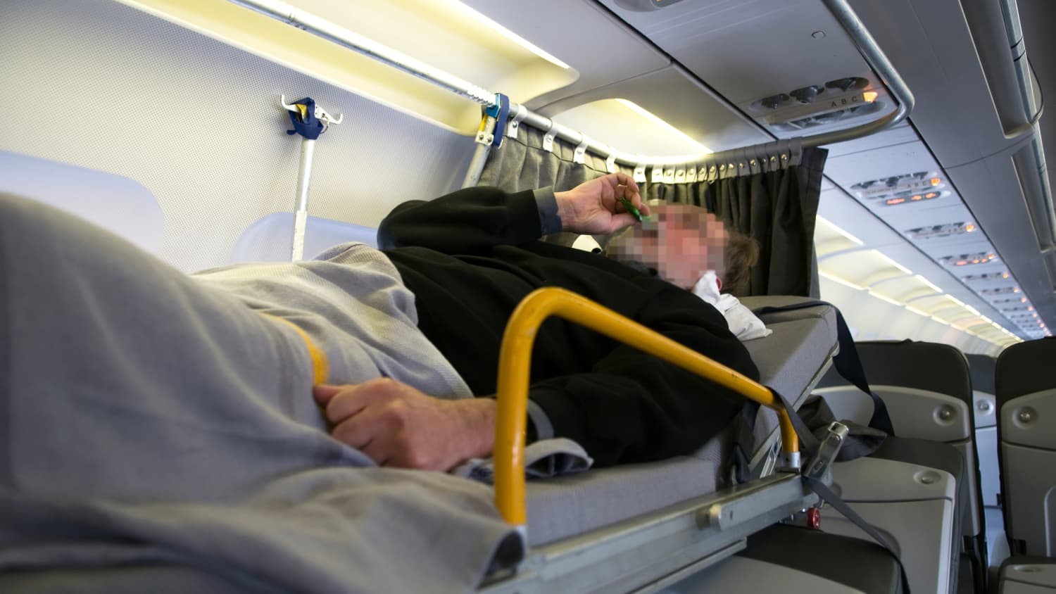 Verletzter wird auf Stretcher im Flugzeug transportiert