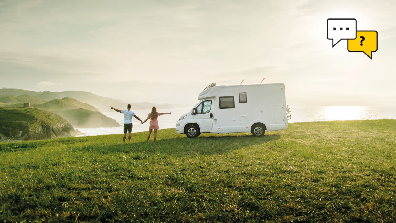 Paar steht neben seinem Wohnmobil und blickt aufs Meer
