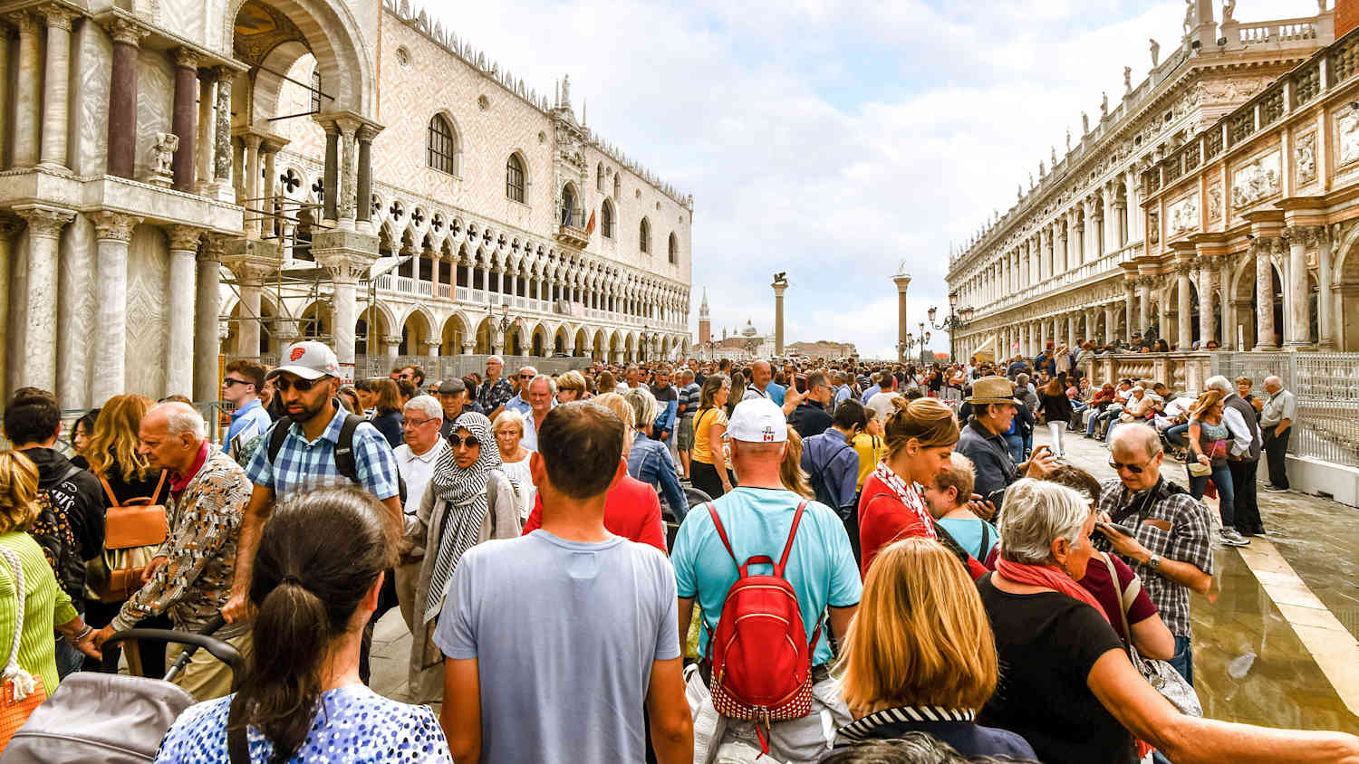 Unzählige Touristen tummeln sich am Markusplatz in Venedig in Italien