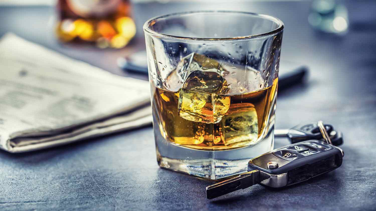 Ein Glsd Wiskey steht auf dem Tisch, daneben liegt ein Autoschlüssel