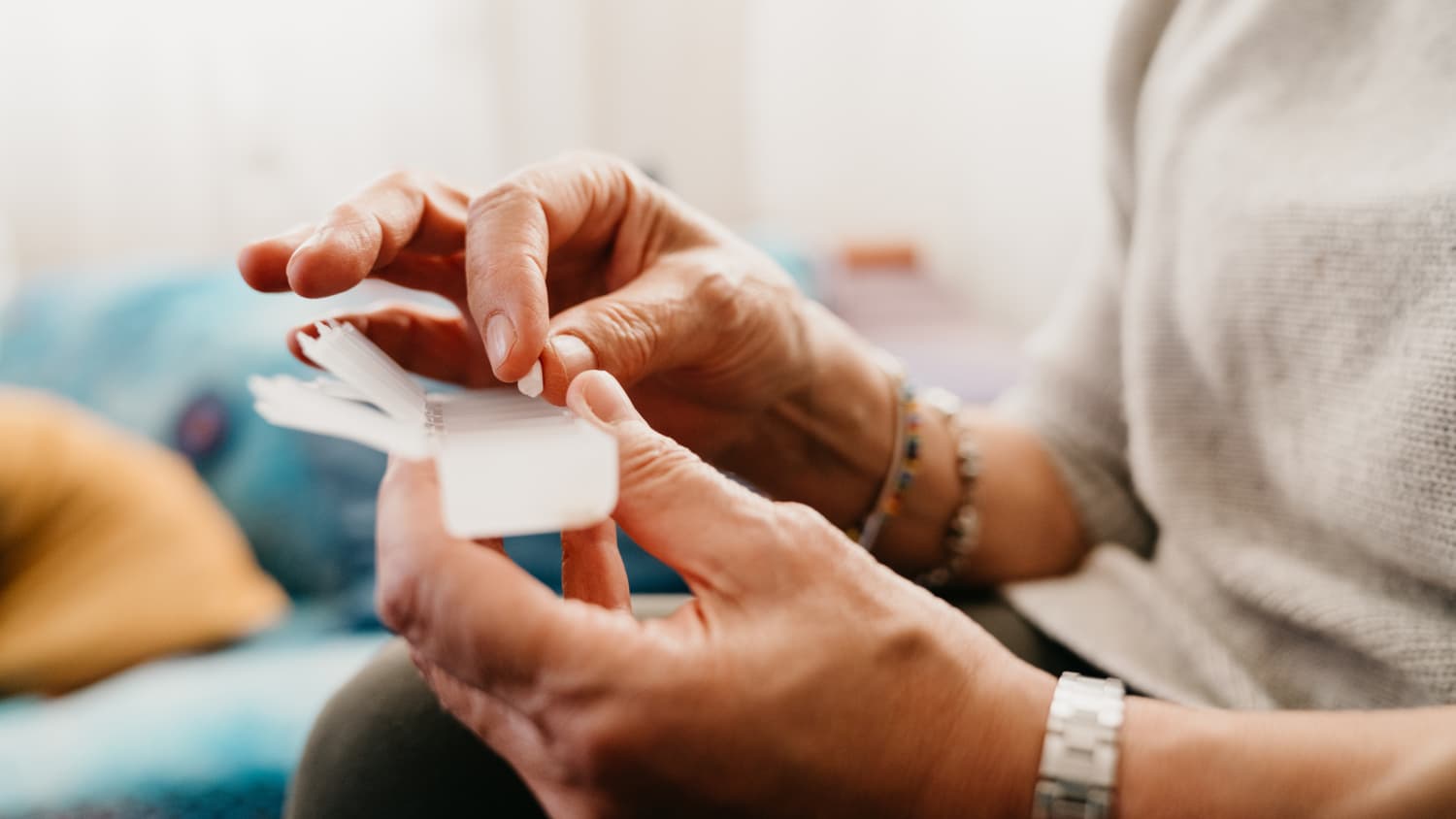 Eine Frau nimmt eine Tablette aus einer Pillendose