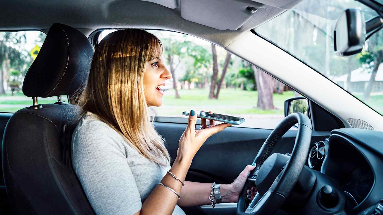 Eine Frau die während der Autofahrt ihr Handy benutzt