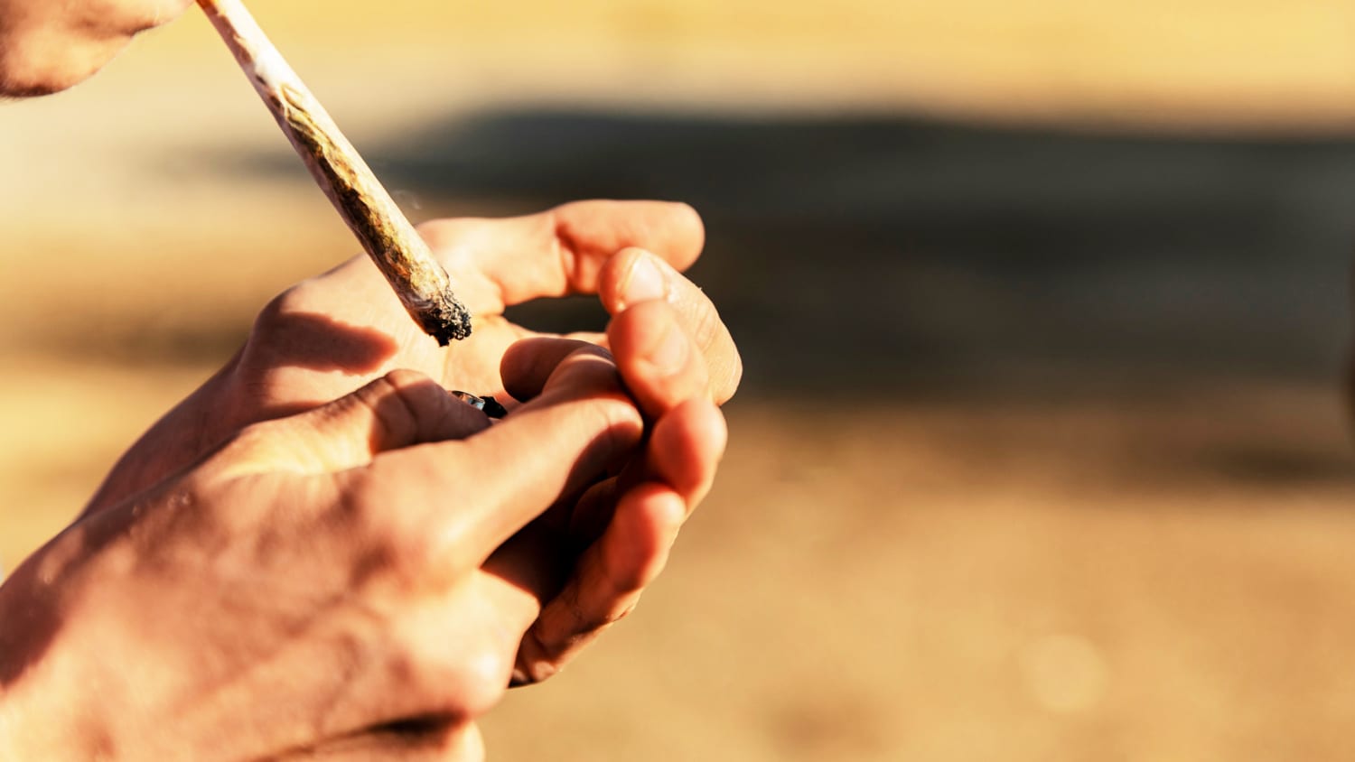 Ein junger Mann zündet sich einen Joint an