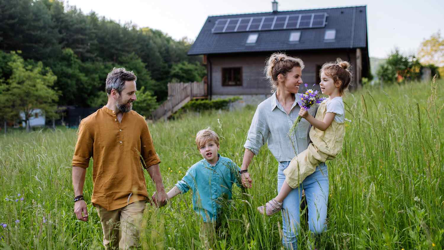 EIne Familie läuft über eine Wiese