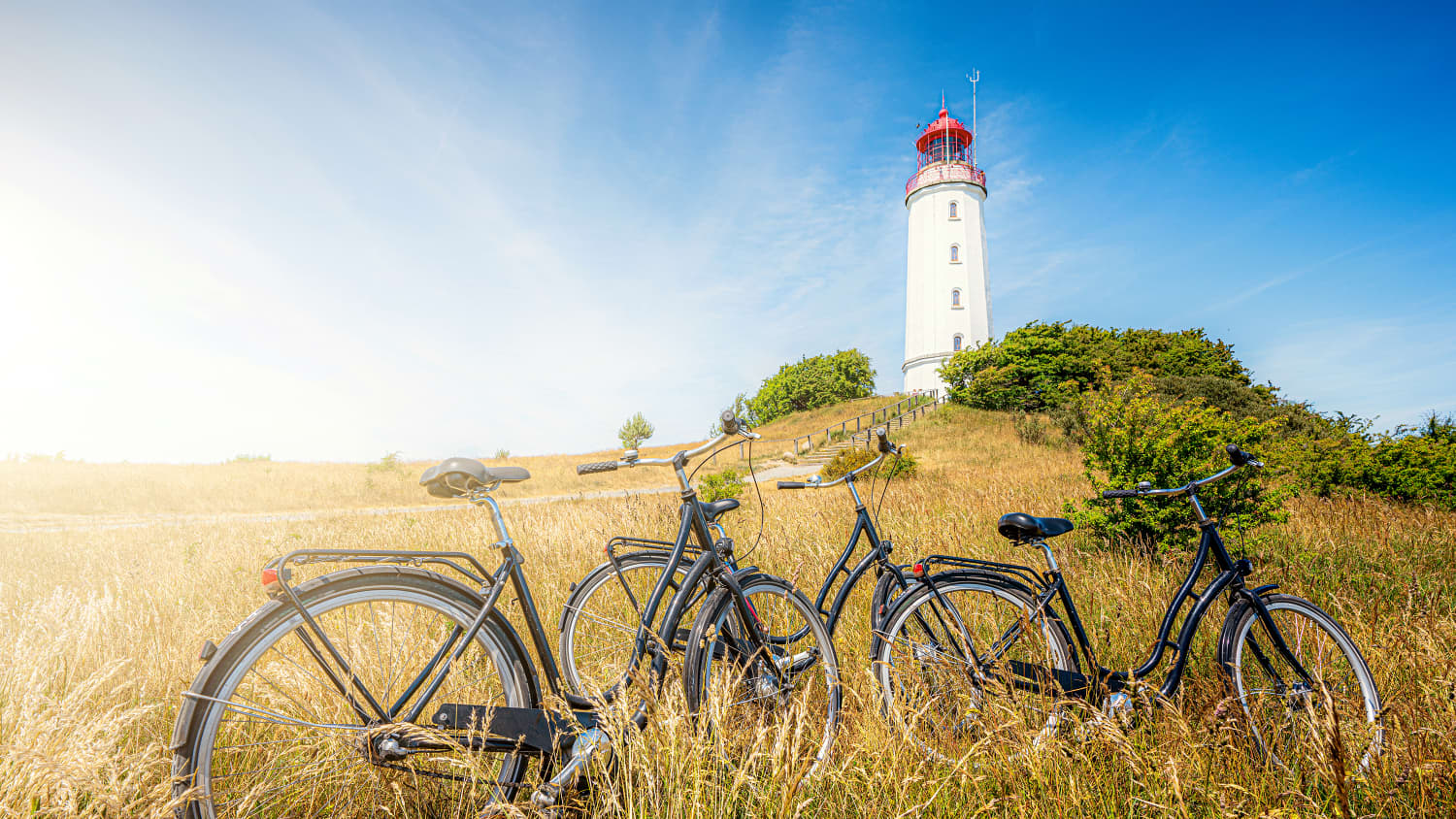Fahrrader stehen auf einer Wiese vor dem Leuchtturm Dornbusch auf der Ostseee Insel Hiddensee