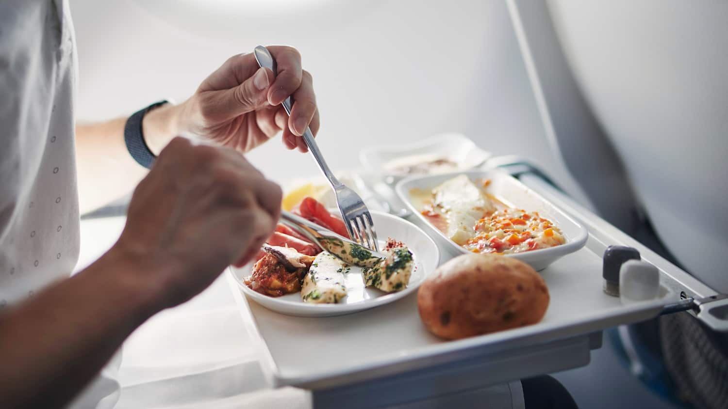 Ein Mann der sein Mittagessen im Flugzeug genießt