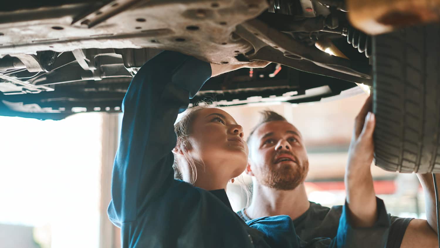 Ein KFZ Meister berät eine Frau bei der Autoreperatur