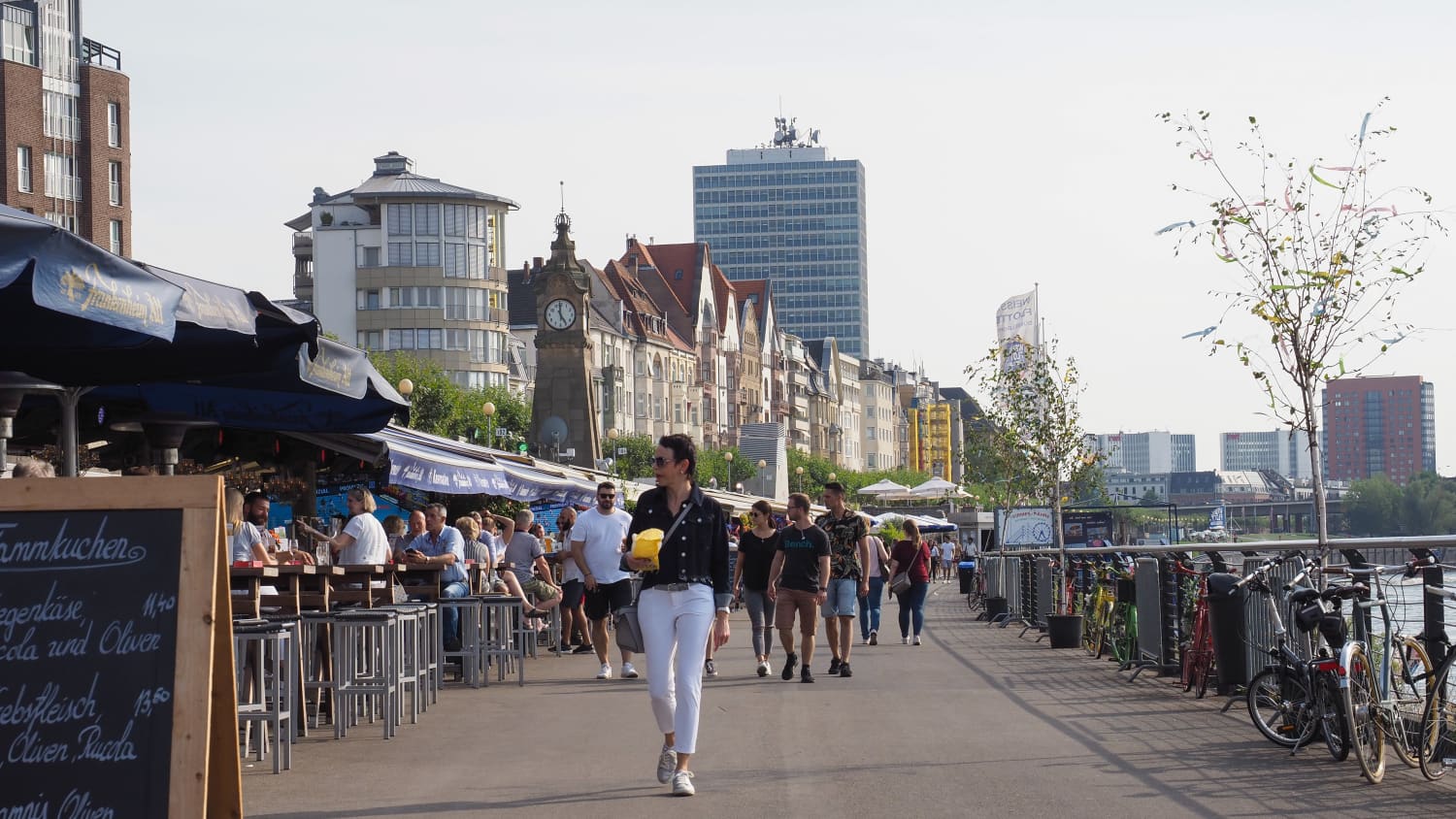 Leute schlendern entlang des Rheins an der Rheinuferpromenade in Düsseldorf