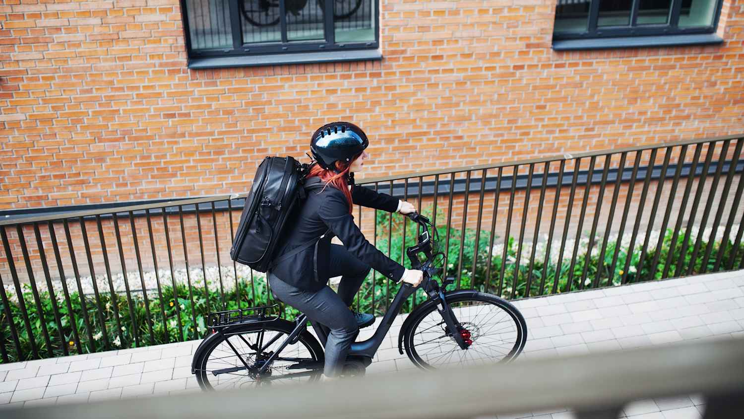 Eine junge Frau die in der Stadt E-Bike fährt