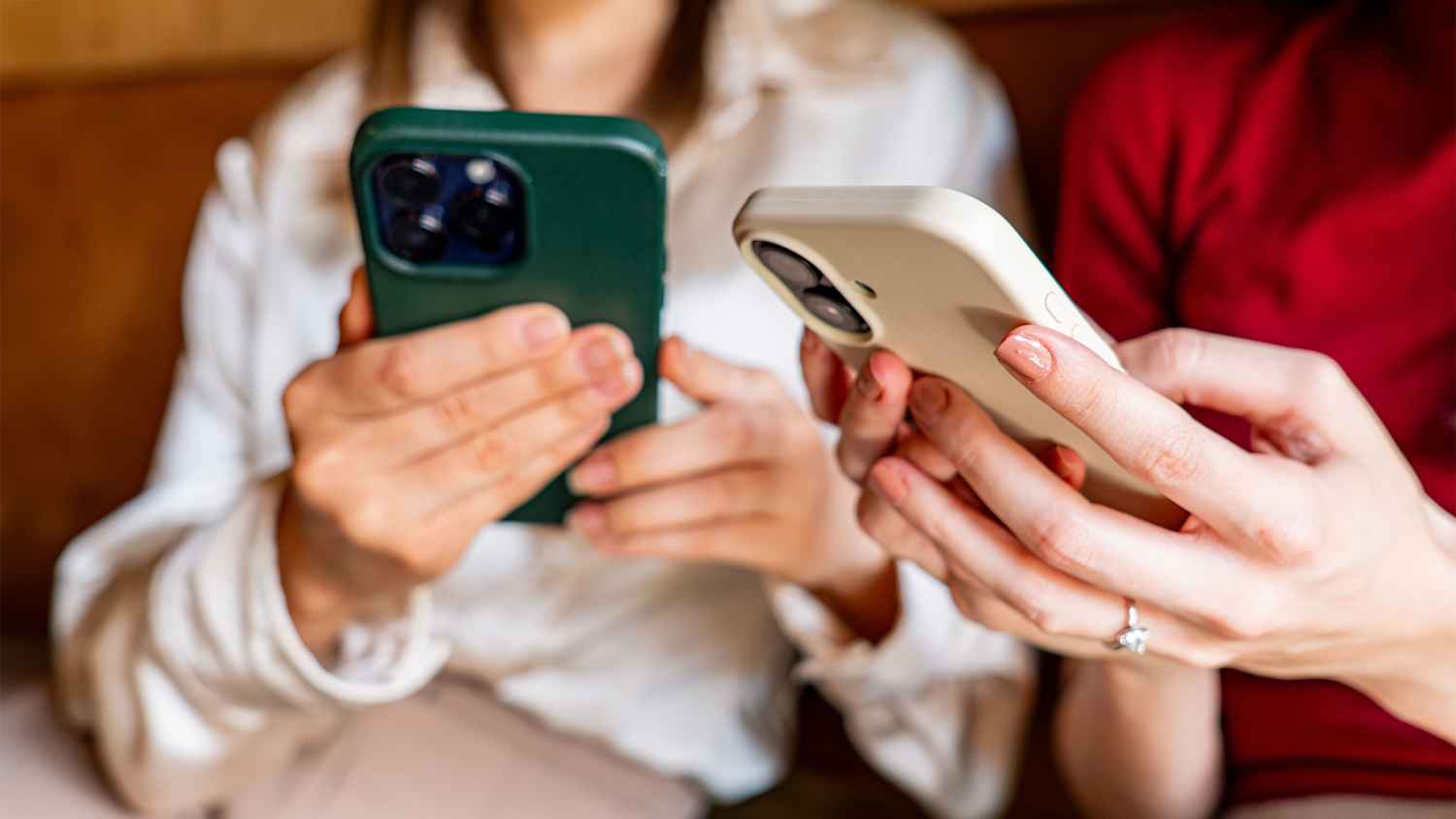 Nahaufnahme zweier Frauen die ihre Smartphones in Händen halten