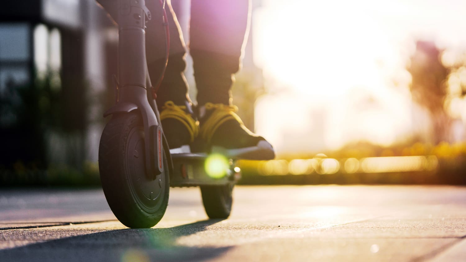 Füße eines Mannes auf einem E-Scooter