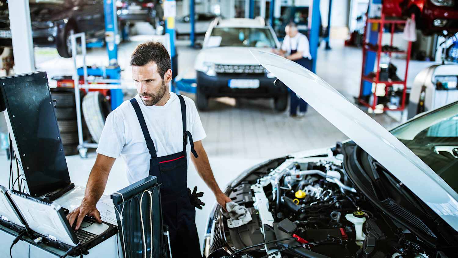 Mann prüft Auto in einer Werkstatt