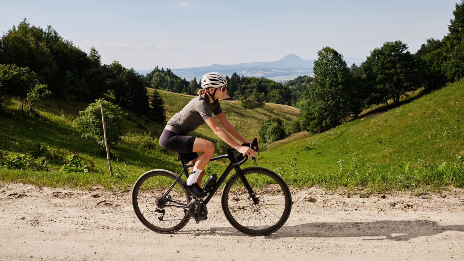 Eine Frau die auf einem Gravel Bike durch die Berger fährt