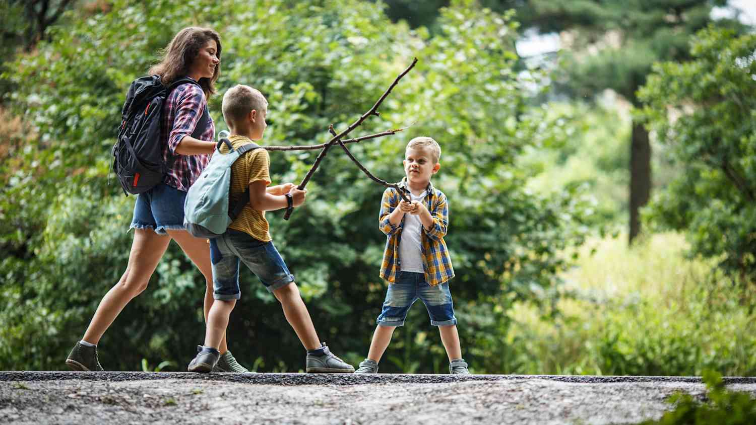 Eine Mutter mit ihren 2 Kindern auf einer Wanderung durch den Wald