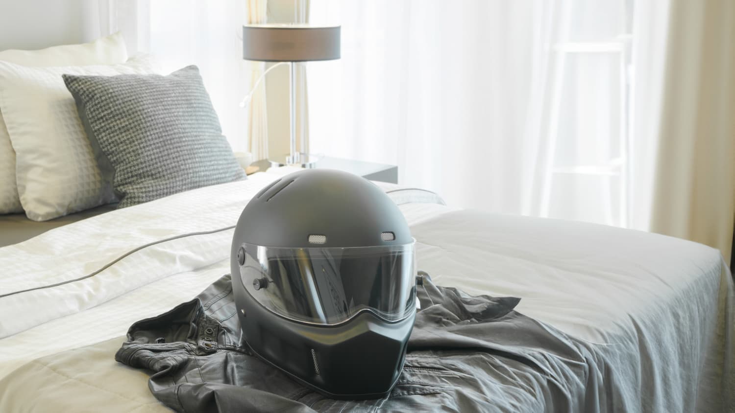 Ein Motorradhelm liegt auf einem Hotelbett